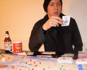 Rob admires the lovingly illustrated 'Regime Change' card.