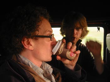 Early Thursday morning, travelling down to London. Andy T injects caffein straight into his mouth, while Tom offers a revolutionary salute.